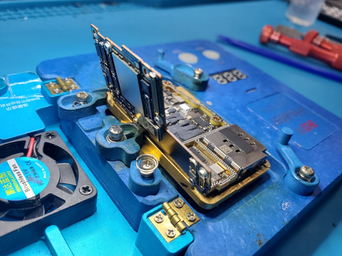 二層構造ロジックボードを専用治具に固定して点検している様子